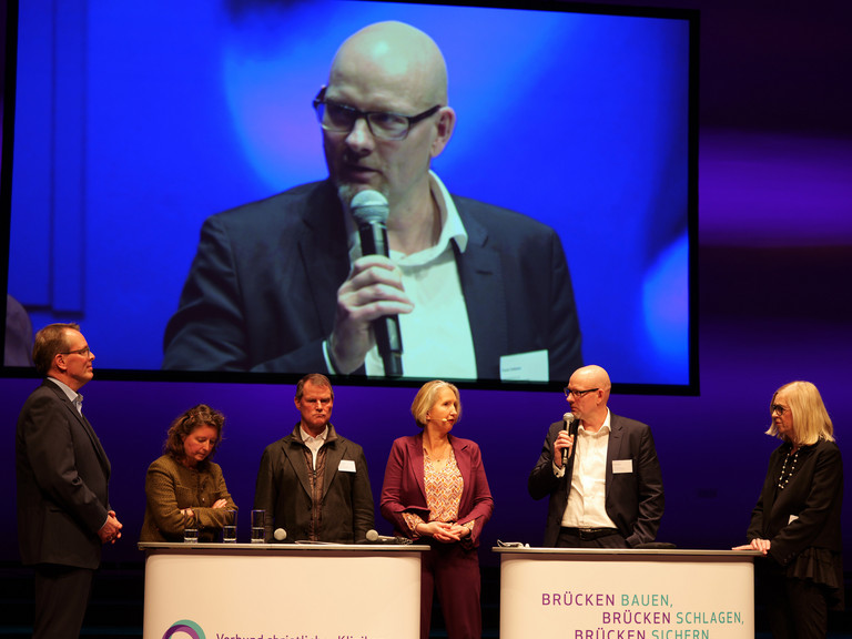 Frank Volkmer redet mit weiteren Vertreterinnen und Vertretern des Brandenburger Gesundheitswesens auf der Bühne Frank Volkmer redet mit weiteren Vertreterinnen und Vertretern des Brandenburger Gesundheitswesens auf der Bühne