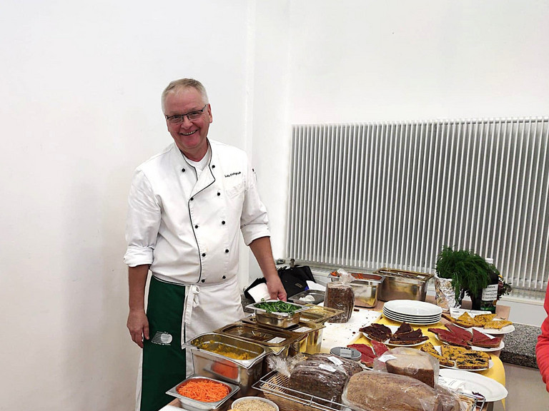 Lutz Fohgrub steht an einem Tisch mit Essen Lutz Fohgrub steht an einem Tisch mit Essen